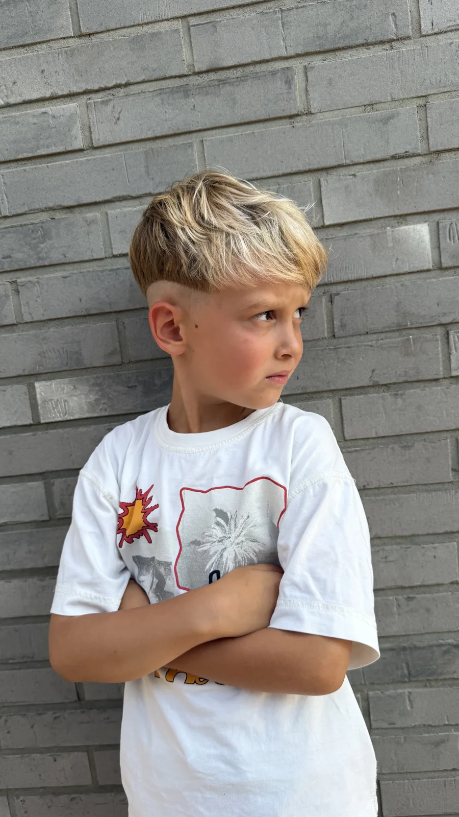Chłopiec po strzyżeniu, z krótką blond fryzurą